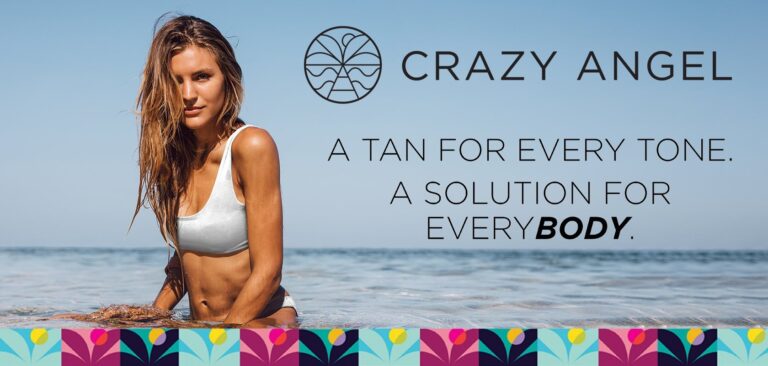 Portrait of beautiful young woman in bikini sitting in sea water. Young woman relaxing on the beach and looking at camera.